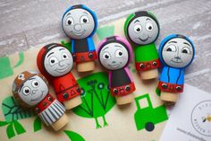 some wooden toys are sitting on top of a piece of paper with an image of thomas the train