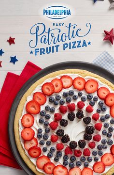 a pie with berries and blueberries on it sitting on top of a red white and blue napkin