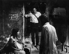 an old black and white photo of a man standing in front of a doorway with two women