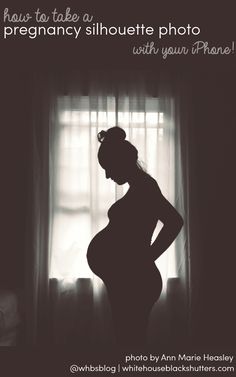 a pregnant woman standing in front of a window