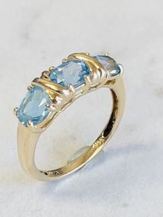 "14kt Yellow Gold Lady's Three Gemstone Oval Blue Topaz Ring consisting of 3- 6mm x 4mm genuine Oval Blue Topaz Gemstones all prong set with an \"X\" of Gold in between each oval Gemstone. This is a \"0X0X0\" Hugs and Kisses Ring. The finger size is 7. This item would Retail for $ 595.00" Oval Blue Topaz Three Stone Ring, Classic Blue Topaz Ring For Anniversary, Classic Topaz Birthstone Ring For Anniversary, Classic Blue Topaz Three-stone Rings, Classic Blue Topaz Three Stone Rings, Classic Three-stone Blue Topaz Rings, Classic Three Stone Blue Topaz Ring, Garnet Pendant, Hugs And Kisses