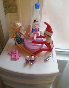 the elf is cleaning the sink in the bathroom with her doll and toothbrushes