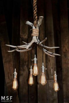 an antler head hanging from a chandelier with light bulbs