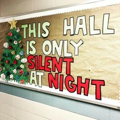 a bulletin board that says this hall is only silent at night with a christmas tree on it