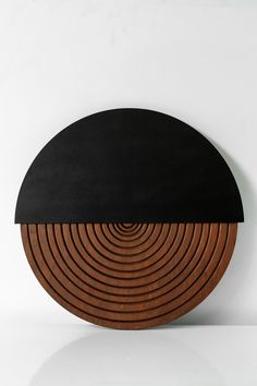 a black and brown circular object sitting on top of a white table next to a wall