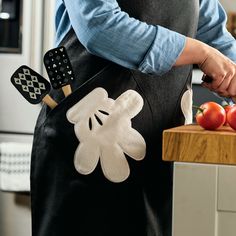 a person in an apron is cutting tomatoes