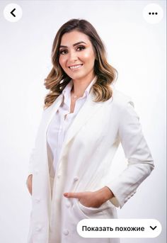 a woman in a white suit posing for the camera with her hands on her hips