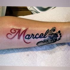 a person with a tattoo on their arm that reads marcel and has an image of a snowboarder