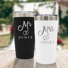 two personalized tumblers sitting on top of a wooden table