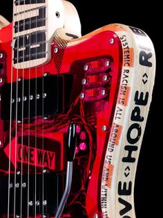 a red and black electric guitar with an advertisement on it's back end that says new hope