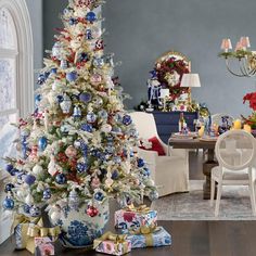 a decorated christmas tree in a living room with blue and white ornaments on the top