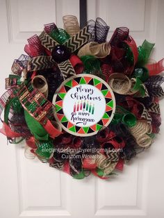 a wreath that says merry christmas and is hanging on the front door with ribbons around it