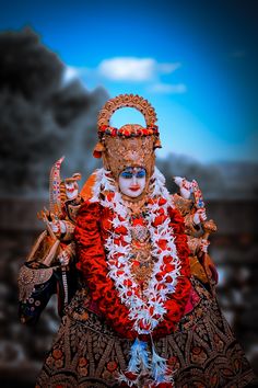 an idol is dressed in red and gold for the occasion of ganesh puja