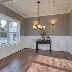 an empty room with hard wood floors and white trim