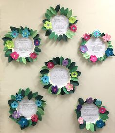 paper flowers are arranged in the shape of wreaths on a wall with poem written below them