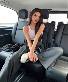 a woman sitting in the back seat of a car