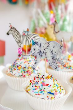 cupcakes decorated with colorful sprinkles and zebra figurines