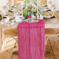 the table is set with plates, silverware and pink linens for an elegant look