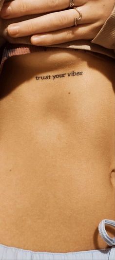 a woman's stomach with the words trust your vibes written on it