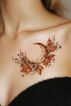 a woman with a tattoo on her chest has a crescent moon and leaves around it