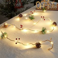 christmas lights and pine cones are on the table