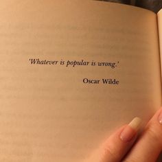 a person holding an open book in their hand with the quote whatever is popular is wrong oscar wilde