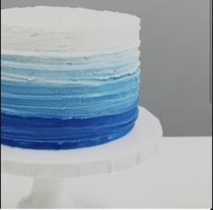 a multi layer cake with blue and white frosting