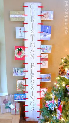 a christmas tree is decorated with red and white ribbons, cards, and pictures on it