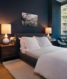 a bedroom with blue walls and white bedding