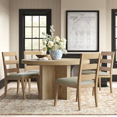 a dining table with four chairs and a vase filled with flowers