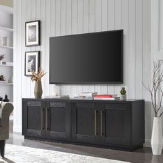 a large flat screen tv mounted to the side of a wooden cabinet in a living room