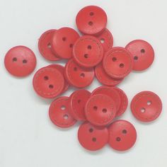 red leather buttons with stitching on white background