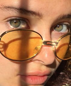 a close up of a person wearing glasses with their reflection on the lens and behind them is a woman's face