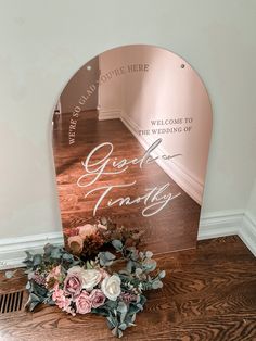 a bouquet of flowers sits on the floor next to a mirror that reads, great wedding