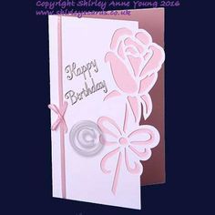 a birthday card with a pink rose and ribbon on the front, and a bow at the bottom