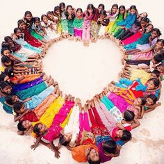 a group of people standing in the shape of a heart