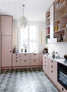 a kitchen with pink cabinets and white counter tops