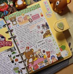 an open notebook sitting on top of a table next to stuffed animals and teddy bears