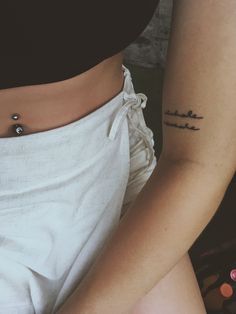 two people with tattoos on their stomachs and one has a small tattoo that reads, i love you