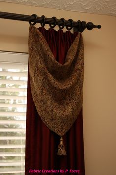 a curtain with a tassel hanging from it's side in front of a window