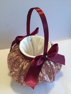 a basket with a bow on it sitting on top of a white tablecloth covered surface