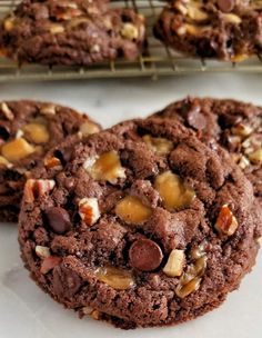 chocolate cookies with walnuts and pecans are cooling on a rack in the kitchen