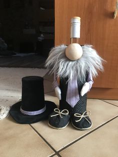 a hat and boots are on the floor next to a wine bottle in a top hat