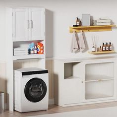 a washer sitting next to a dryer in a room with white walls and wooden floors