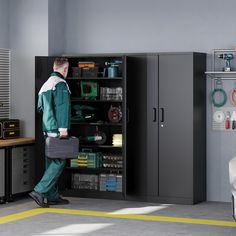 a man in green work clothes is holding a tool box and looking into a storage cabinet