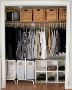 an organized closet with clothes, shoes and baskets on the shelves in front of it