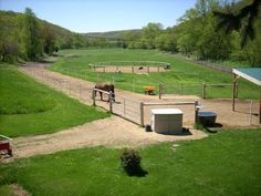 there are horses that are standing in the fenced off area at this farm yard