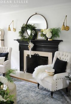 a living room decorated for christmas with white furniture and greenery on the mantel