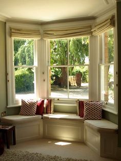 the sun shines through two large windows into a room with white furniture and pillows