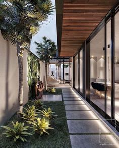 an outdoor area with grass and plants next to a house that has sliding glass doors on both sides